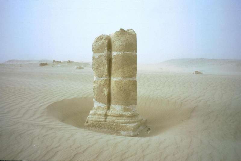 an ancient pillar in a sand bowl